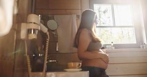 Pregnant woman looking out window