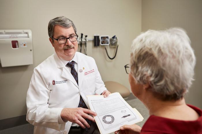 Douglas Scharre, MD, discusses the results of a cognitive test with a patient at The Ohio State University Wexner Medical Center.