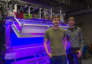 Postdoctoral researcher David Stupski, left, and Assistant Professor Floris van Breugel stand in front of a wind tunnel at the University of Nevada, Reno.