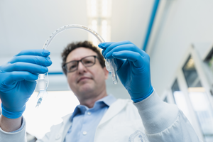 Professor Ben Hatton holds up flexible tubing