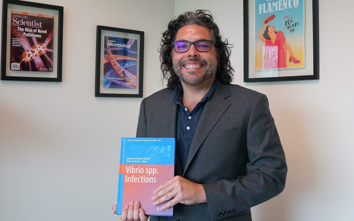 Dr. Salvador Almagro-Moreno holds his recently published book Vibrio spp. Infections.