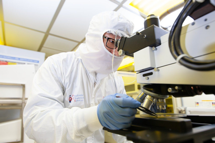Yuhao Zhang works in a clean room on semiconductor technologies.