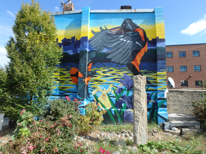 Rain garden in a vacant lot in Baltimore's McElderry Park neighborhood that includes a mural.