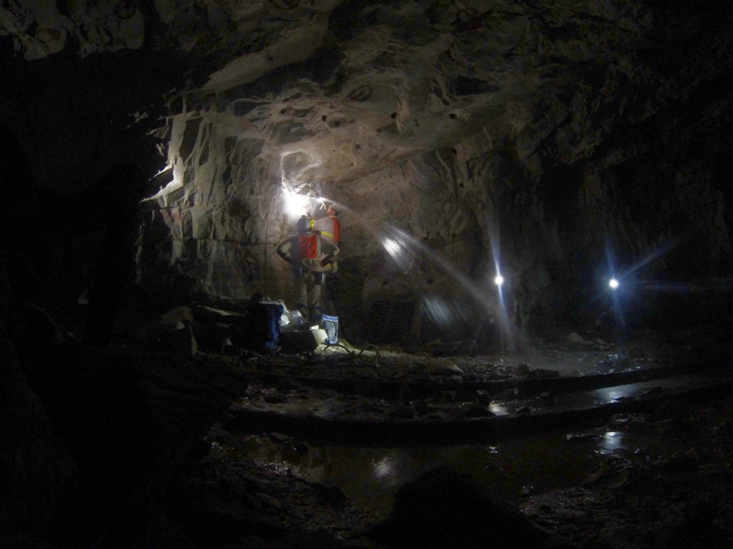 Two Men in Subterranean Cave with Ancient Water