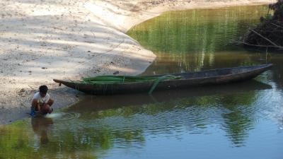 Shuar Boy Filling Water Gourd in River
