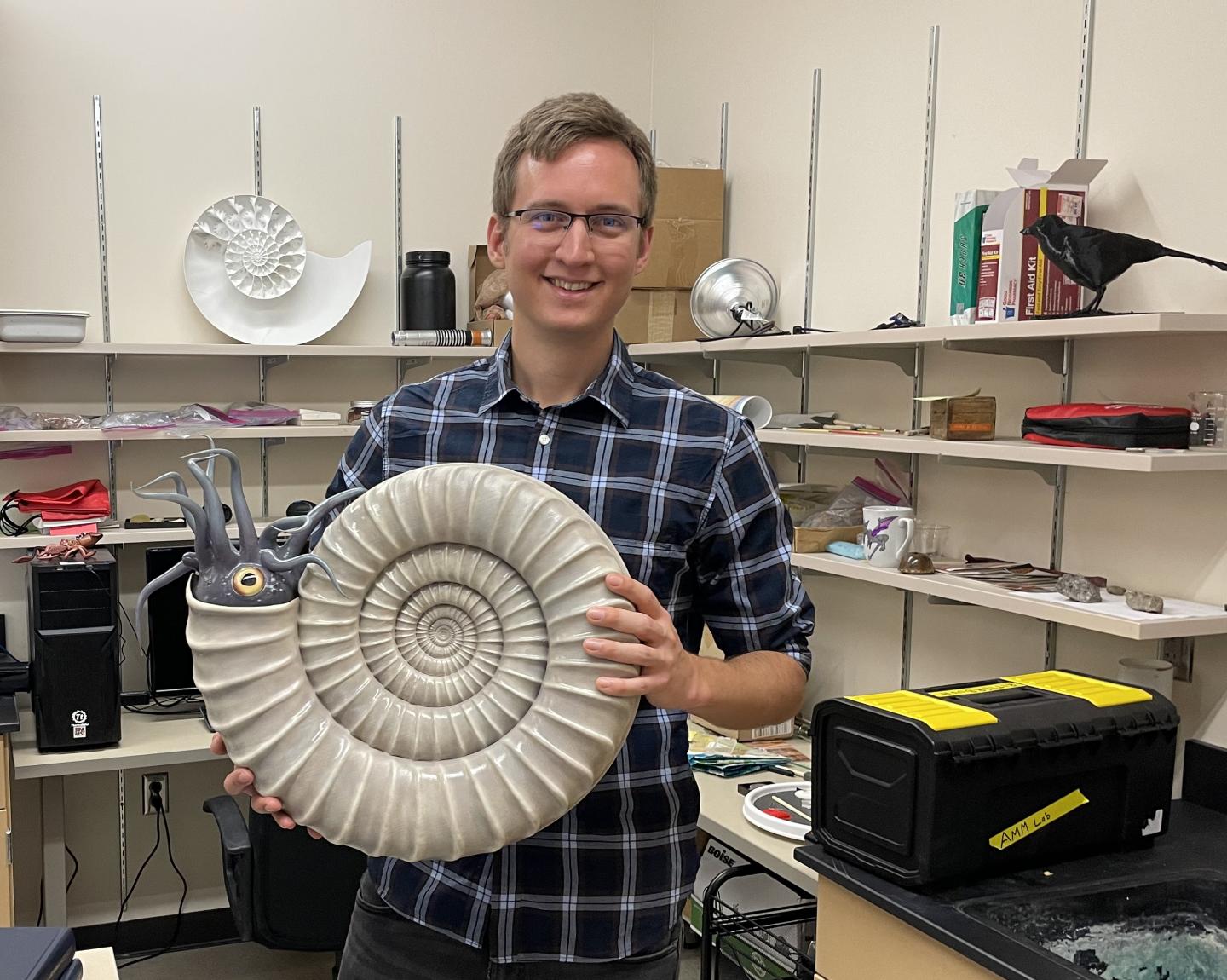 David Peterman in the AMMLab holding a 3-D-printed ammonite, Paracoroniceras lyra.