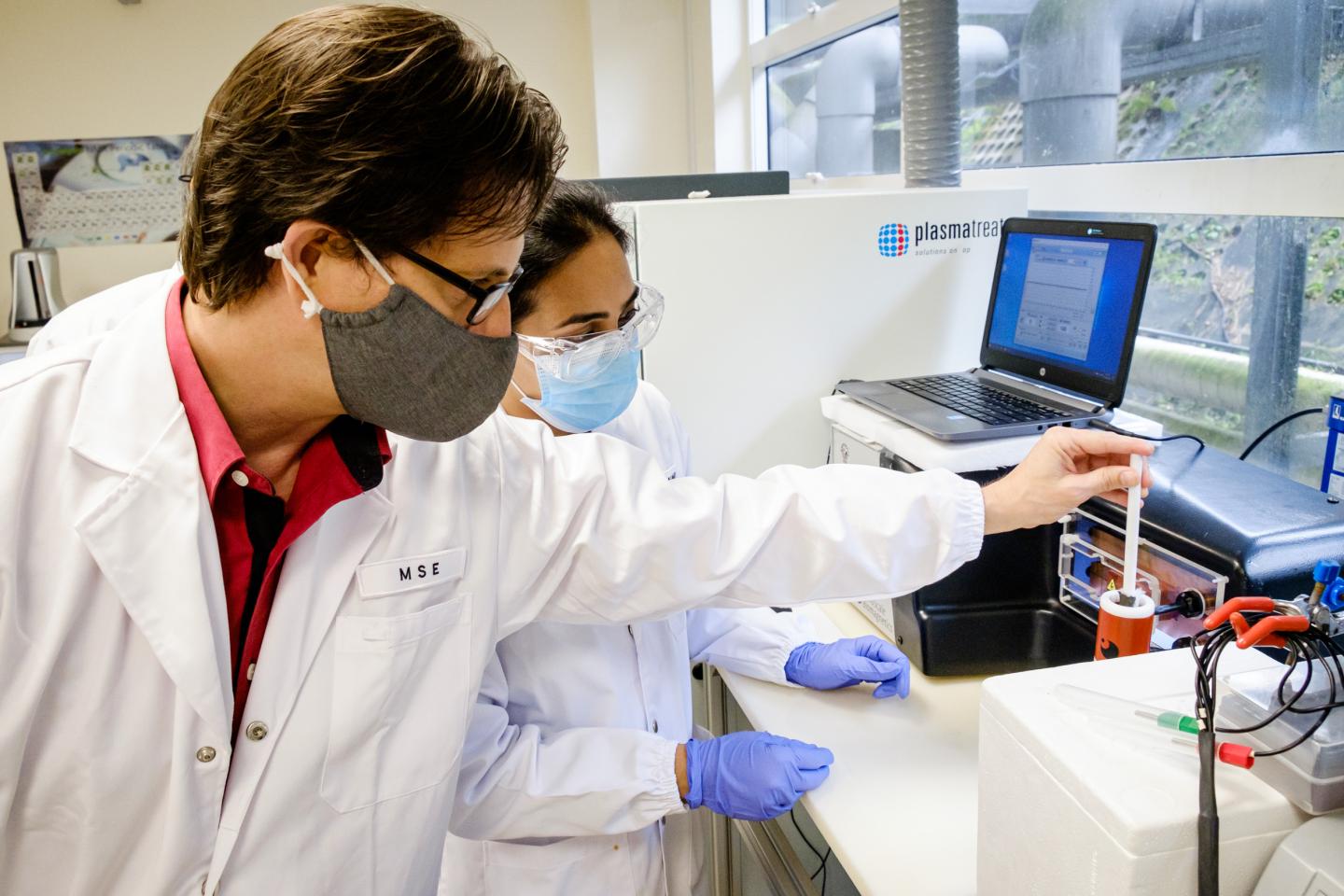 Assoc Prof Steele (left) and Dr Richa curing the magnetocuring glue on a cotton mesh