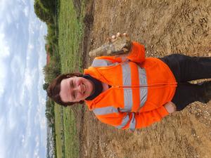 ASE Senior Archaeologist Letty Ingrey holds up one of the handaxes on site