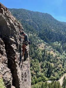 Gunes Kutlu scaling rock faces in Utah’s dramatic landscape.