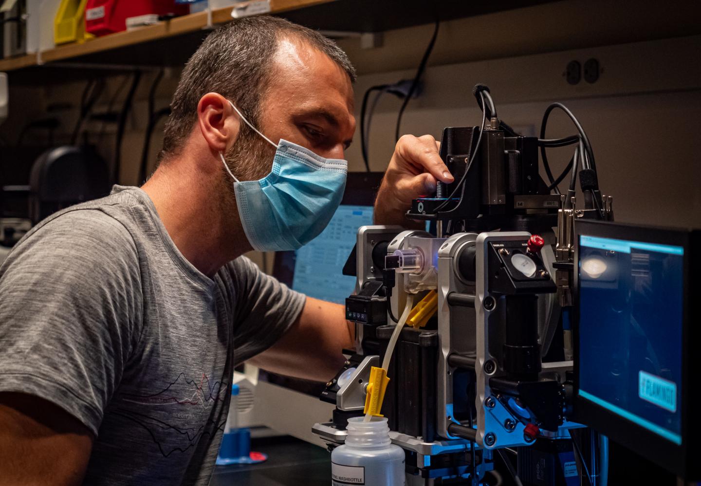 Researcher using microscrope in lab