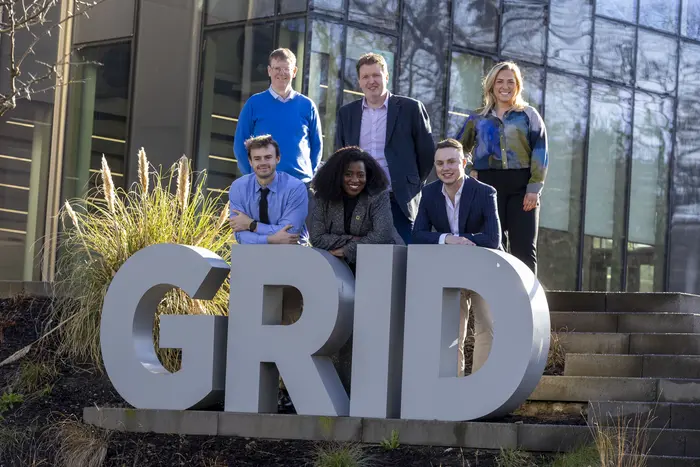 Heriot-Watt University and CGI Stakeholders stand on front of the Heriot-Watt GRID building