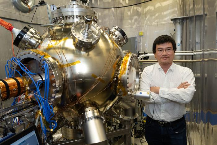 Brookhaven Lab accelerator physicist Erdong Wang with high-voltage polarized electron gun