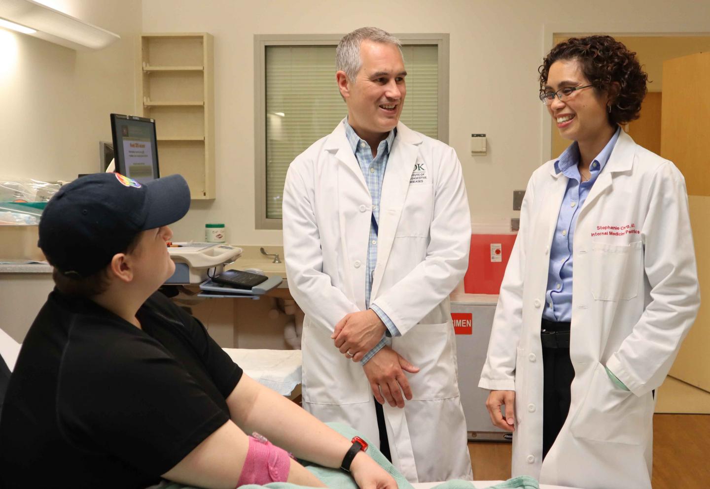 Two Doctors Talk with a Study Participant Sitting in a Hospital Bed