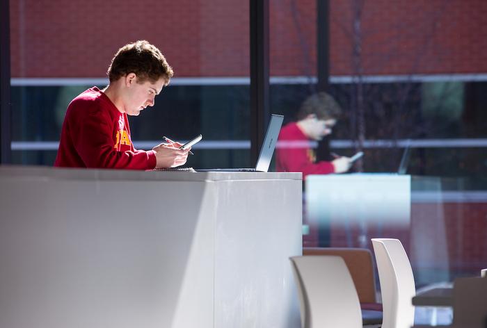 A student looks at his phone in the Student Innovation Center at Iowa State University.