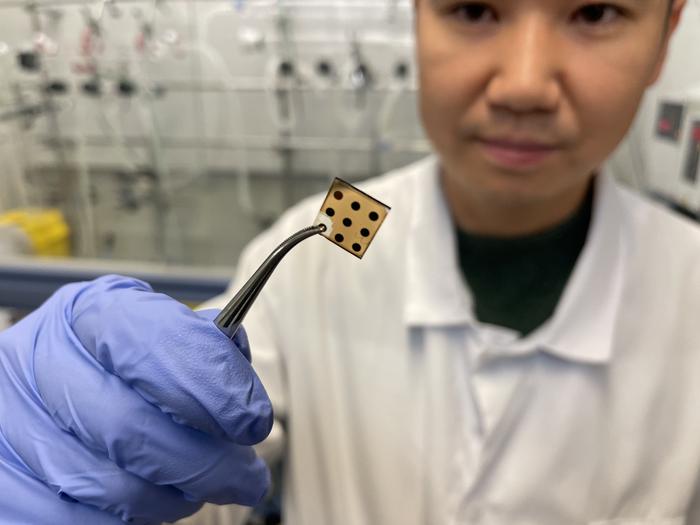 The researcher Lucheng Peng in the lab at ICFO holding the photodetector