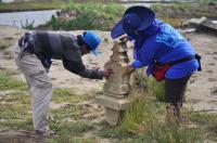 Project staff recording carved Muslim gravestone that was displaced by the 2004 Indian Ocean tsunami.
