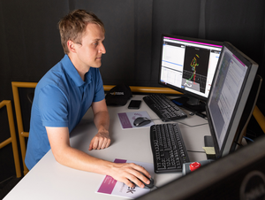 Pawel Golyski uses a computer to operate the CAREN system during an experiment.