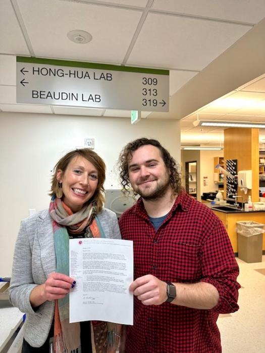 Anna Beaudin, PhD, and Brian Krum holding American Society of Hematology plenary session acceptance letter