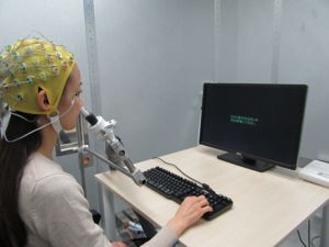 Participant wearing an EEG cap and using the odor delivery device