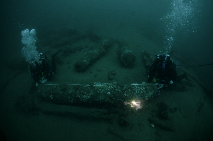 The Barnwell brothers measuring one of the ship's cannons