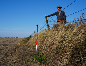 •	Isaac Larsen standing on the erosional escarpment at Stinton Prairie, Iowa.