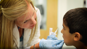 Nurse takes cheek swab from child