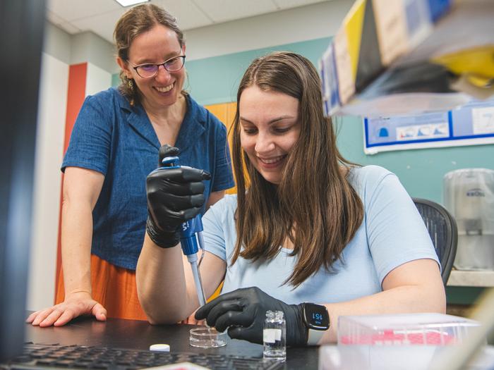 Two researchers pipetting water droplets in the lab