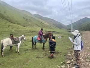 Pastoralists on horseback being interviewed by researchers