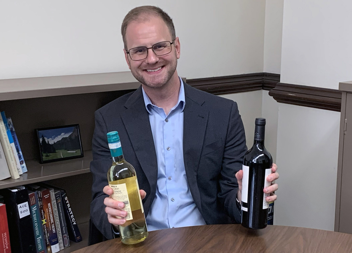 William Ridley holding wine bottles