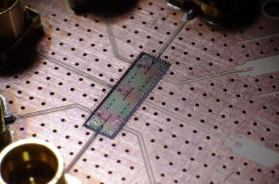 Distant Artificial Atoms Cooperate by Sharing Light