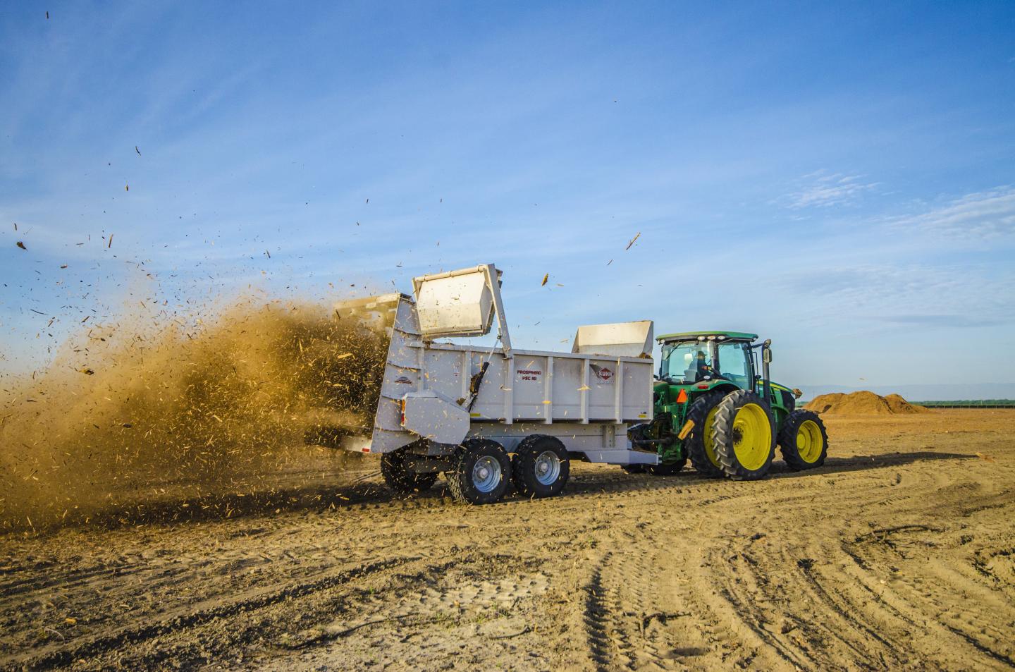 Fowler Brothers spread wood chips at orchard