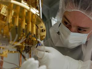 PNNL physicist Ben Loer works with a dilution refrigerator, which cools experimental qubits to near absolute zero.