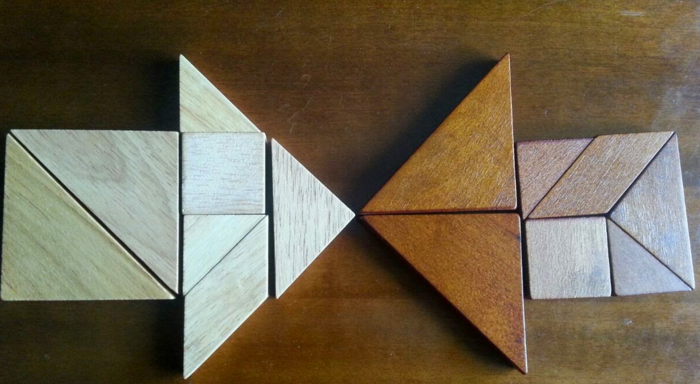 Wooden tangram pieces arranged to form two opposing arrows