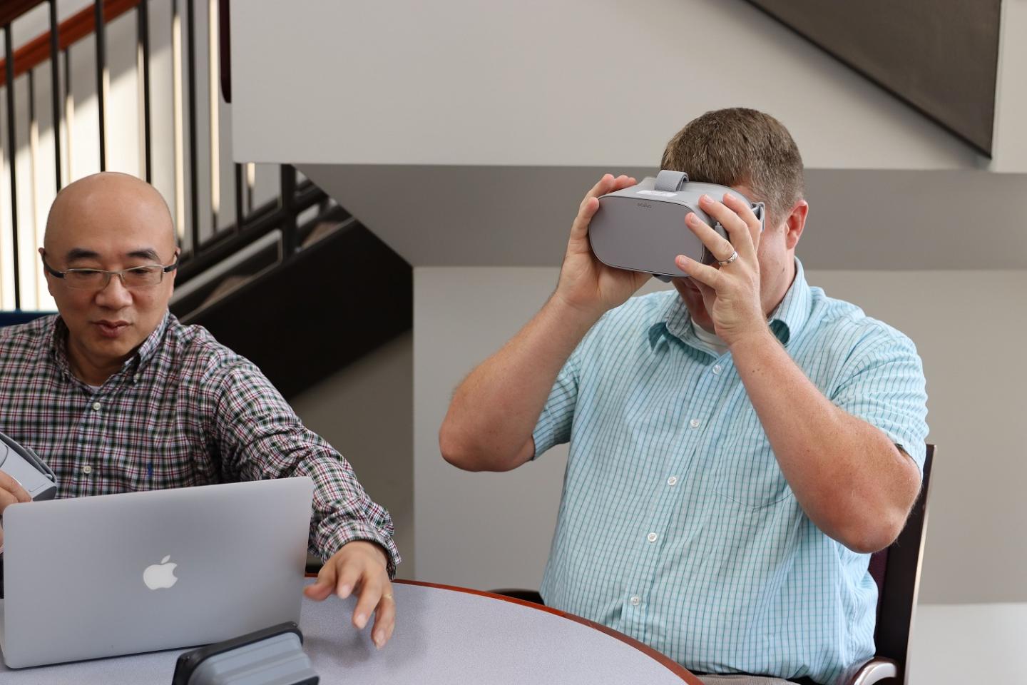 Photo of Cheng Chang Lu with Computer and Karl Kosko Wearing Virtual Reality Goggles