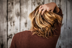 A woman with her hand in her hair.