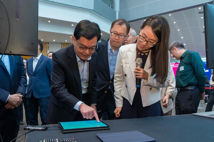 DPM Heng Swee Keat (left) and NTU President Ho Teck Hua (centre), looking at an AI-powered game that can help doctors with early diagnosis and early intervention of diseases such as Alzheimer’s