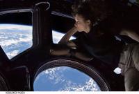 NASA Astronaut Tracy Caldwell-Dyson Looks out a Cupola Module Window at the Earth Below