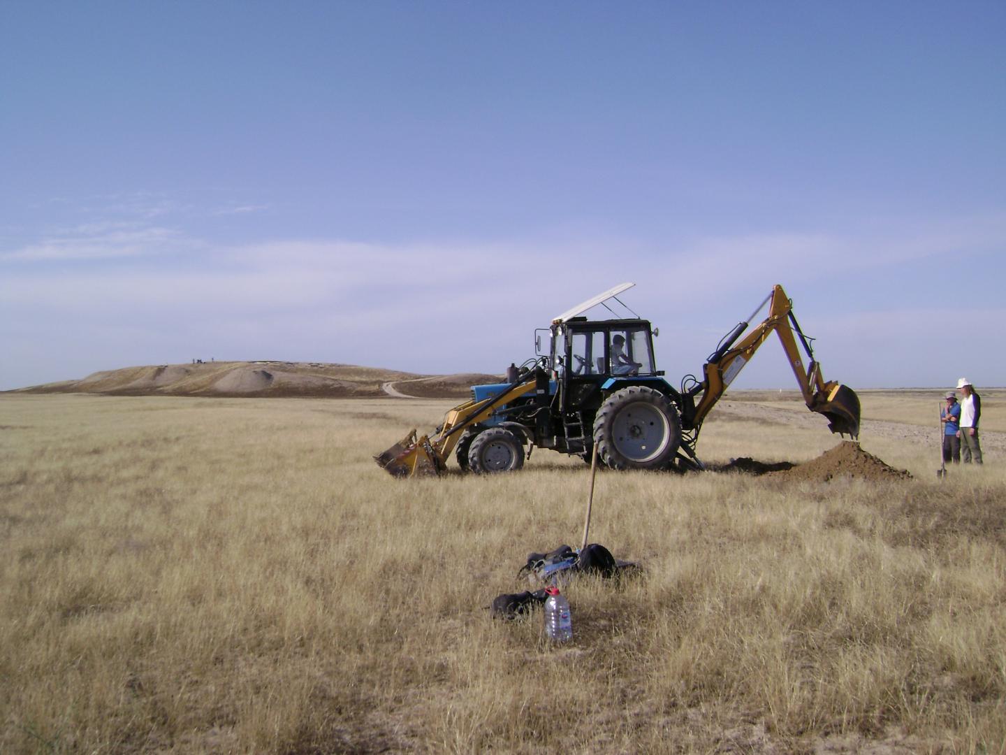Trenching of an ancient irrigation canal north of the fortified settlement of Kuik Mardan (in the background) in Otrar Oasis