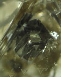 Hexagonal Grain of Iron Sulfide Below a Diamond's Surface Surrounded by a Black Rim