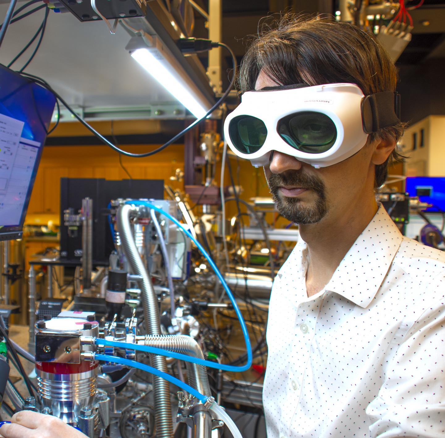 Scientist in the Femtosecond Spectroscopy Unit at OIST Adjusts Laser Settings