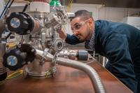 Researcher at Linköping University Making Adjustments to Vacuum Chamber