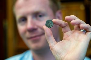 Professor Rory Naismith holding a Byzantine silver coin