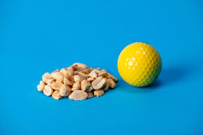 Photo illustration of a serving of nuts, approximately the size of a golf ball.
