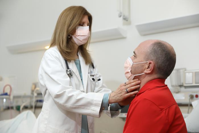 NIDCR researcher examining the neck of a clinical trial participant