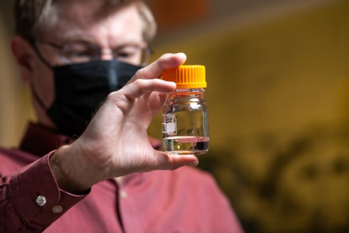Robert Dagle holds a vial of fuel created from biomass conversion.