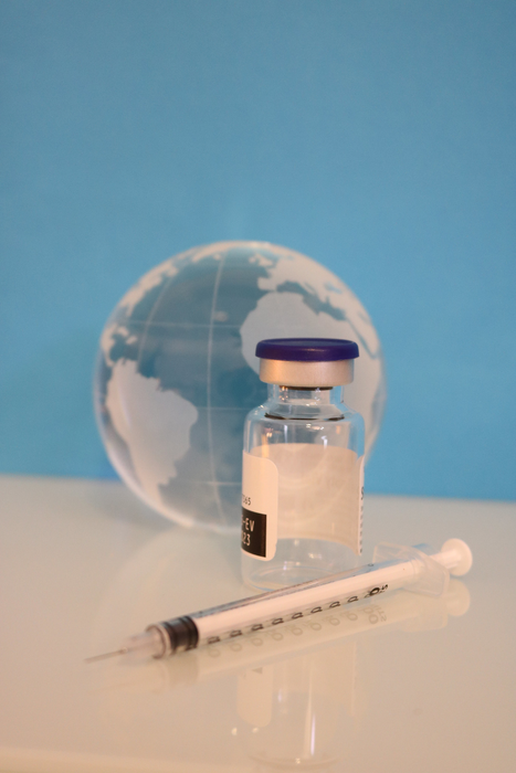 A syringe, vaccine vial, and glass globe.