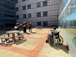 A patient listens to a mariachi performance outside of the Ronald Reagan UCLA Medical Center