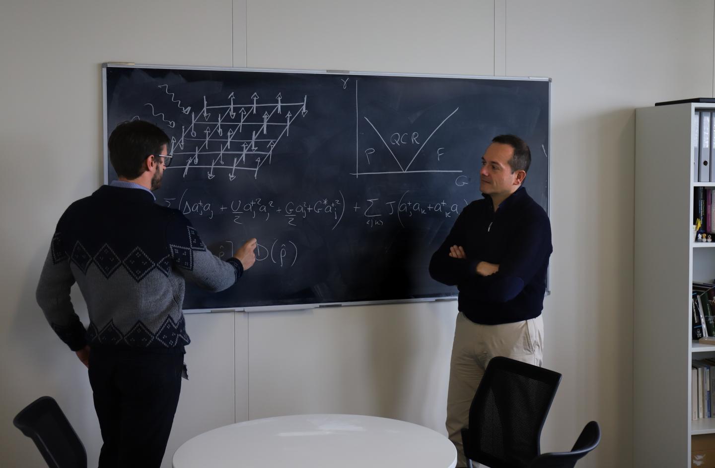 Riccardo Rota and Vincenzo Savona Working on the Design of their Quantum Simulator