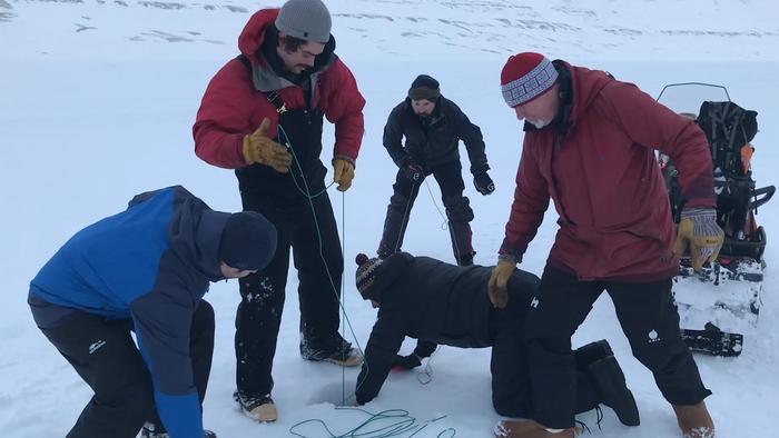 Retrieving a sediment core from Svalbard. François Lapointe, center on his knees.