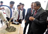 Minister Iswaran Looking at a Concrete 3-D Printing Robot Being Developed at NTU